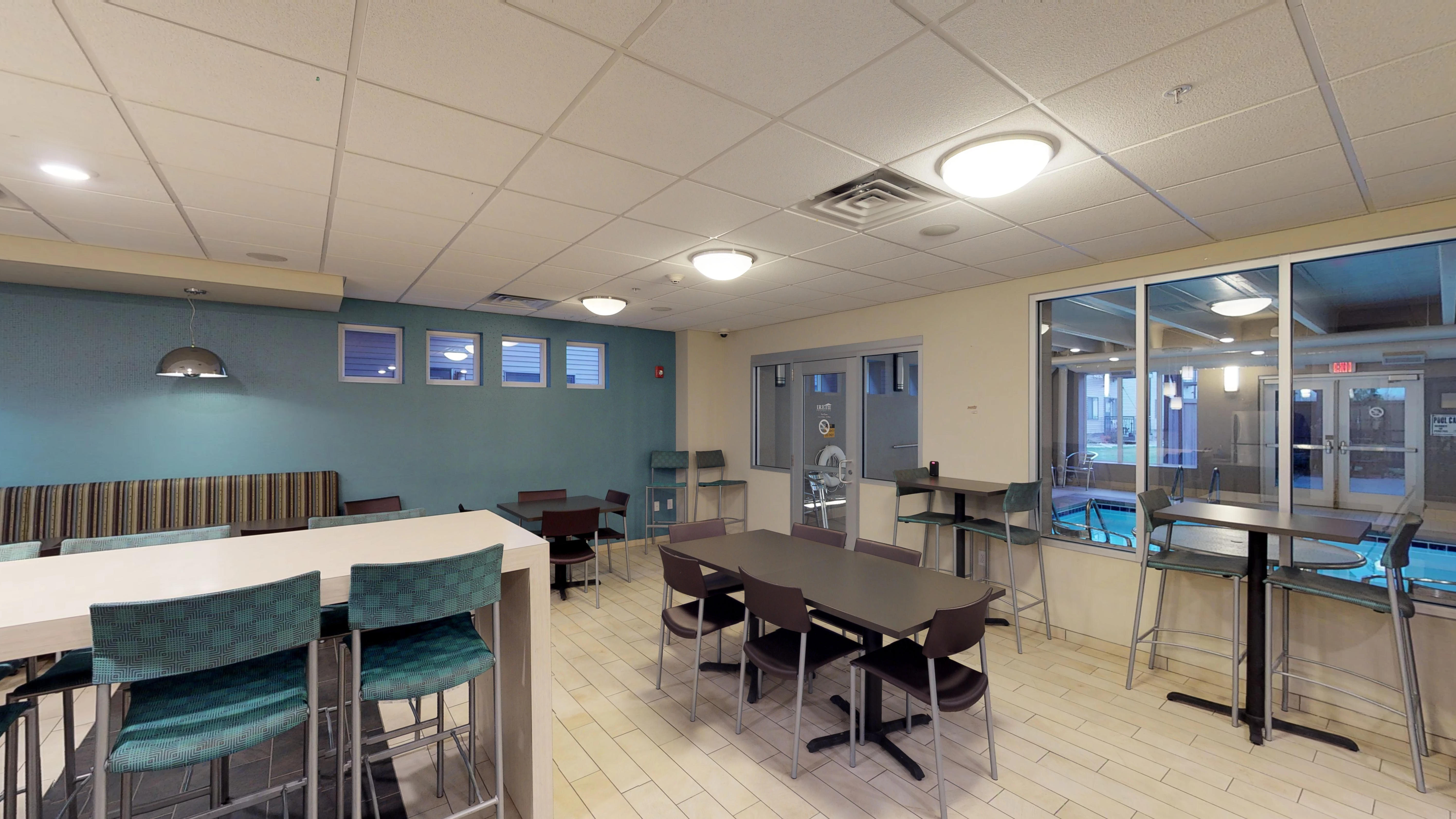 A room with tables and chairs and a pool table.